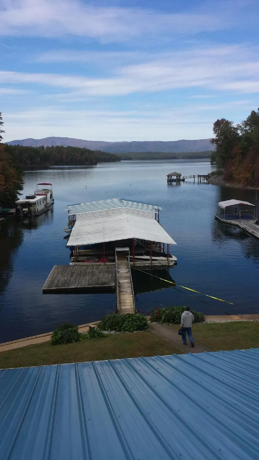 View across a lake from a newly installed blue metal roof in Sand Springs