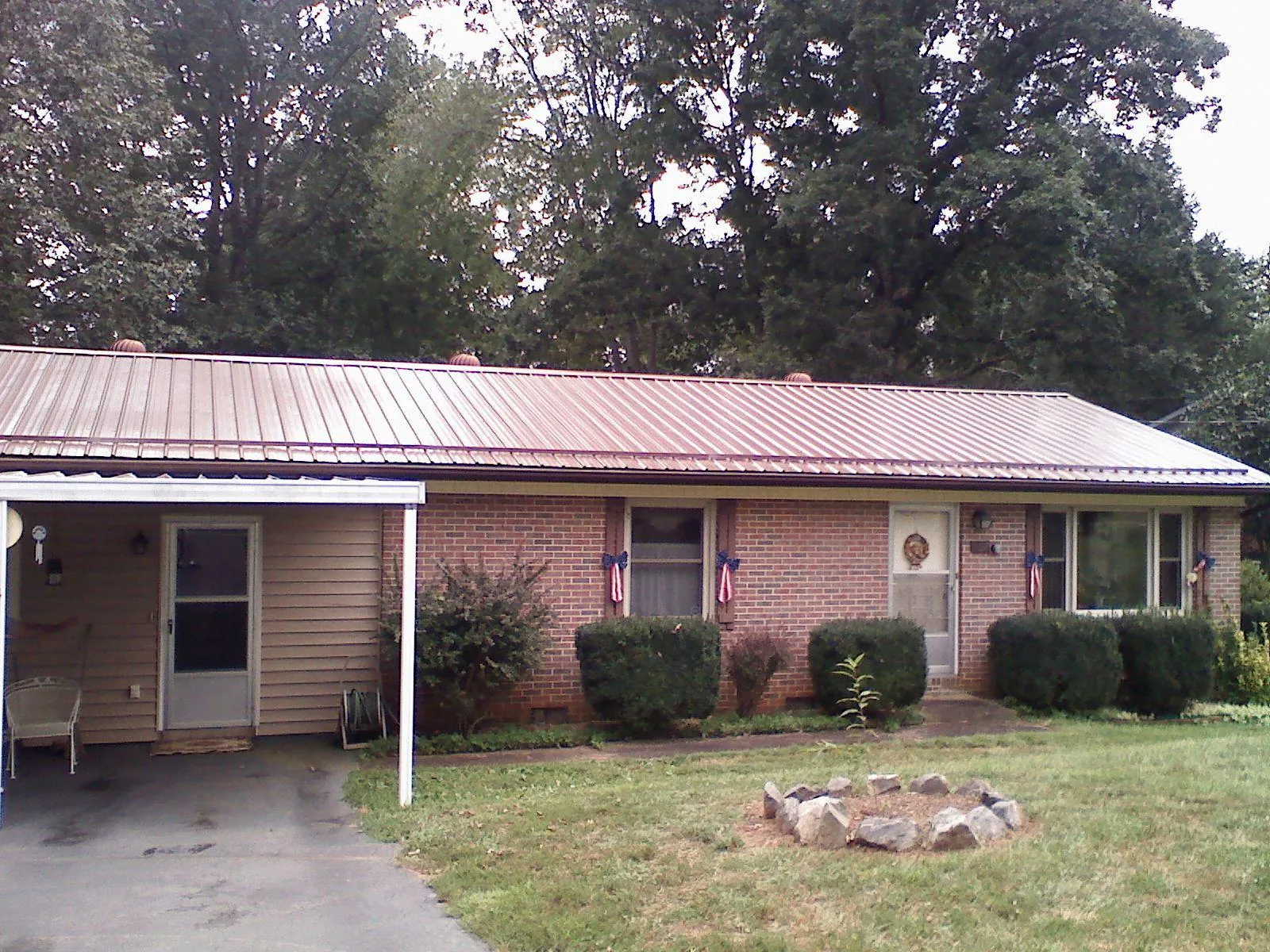 Bronze metal roof and carport on a brick ranch home — Roof Repair work by our crew in Sand Springs