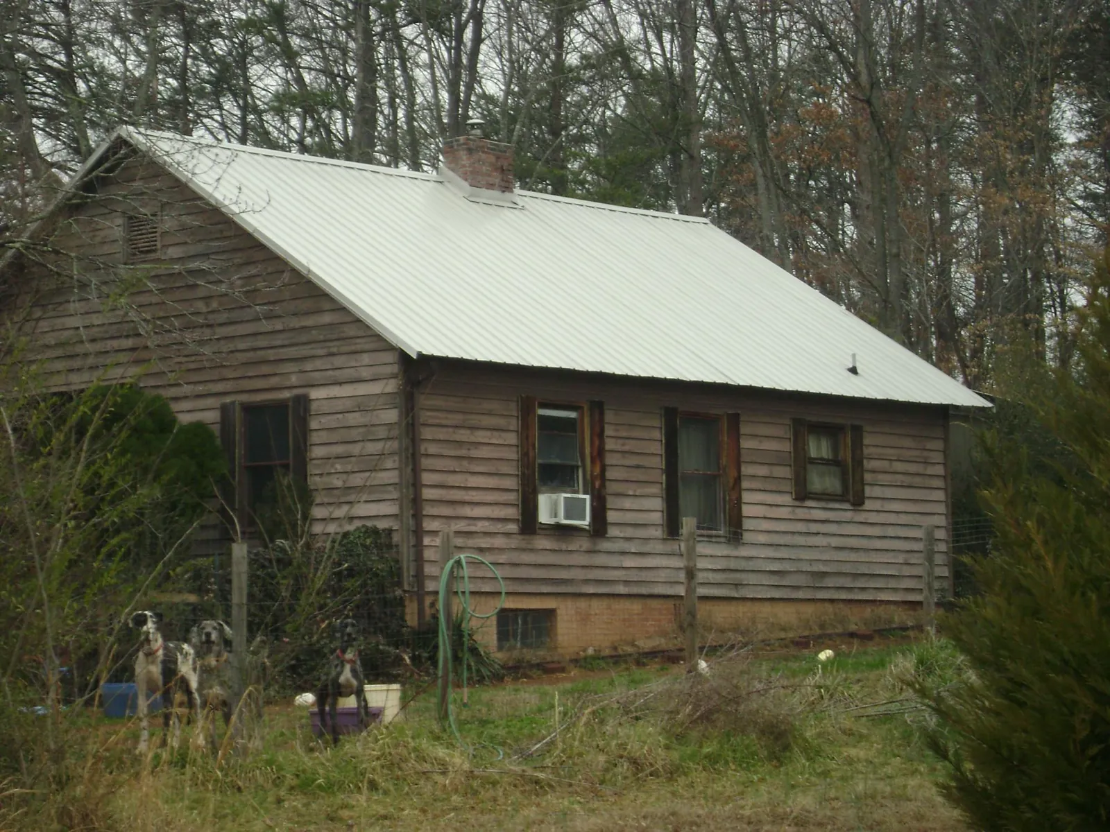 White metal roof on an old wood sided farmhouse, from a Asphalt Shingle Roof Repair job in Sand Springs